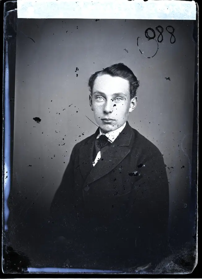 A scratched, spotted studio portrait with ink marks before restoration